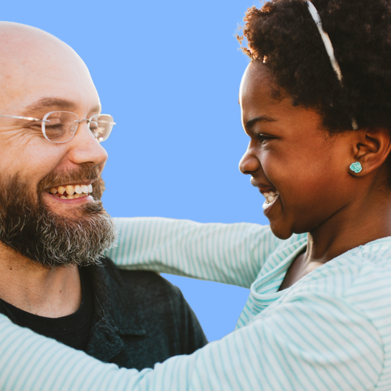 Dad smiling with school-age daughter